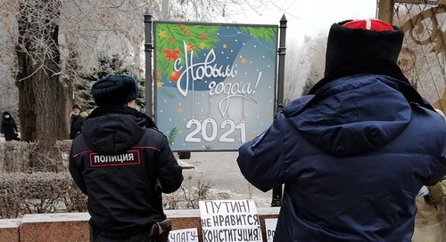 Полицейский и казак записали данные пикетчиков и сфотографировали их плакаты. Волгоград, 31 декабря 2020 года. Фото Татьяны Филимоновой для "Кавказского узла".